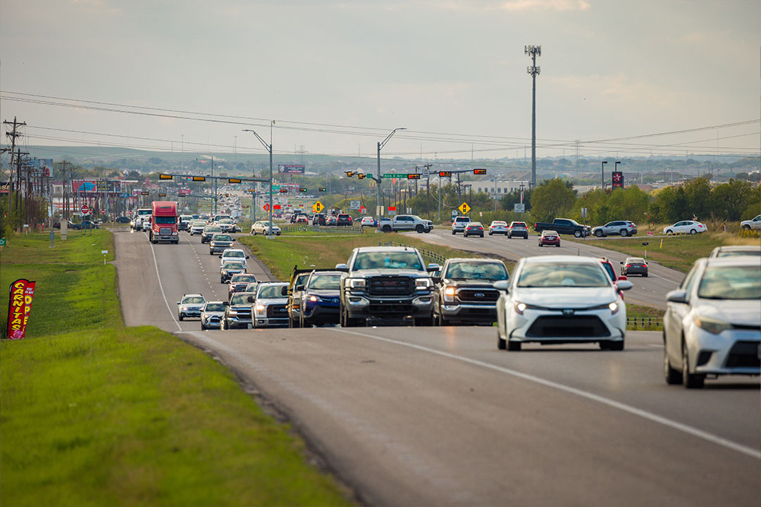 Dense traffic jam on 290 with vehicles extending into the distance under overcast skies