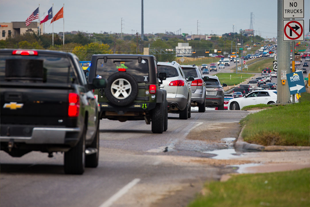 Traffic backup on 290 with emergency vehicles and "No Trucks" signage visible