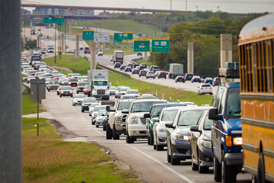 Congested highway traffic with school bus visible among cars and trucks in multiple lanes