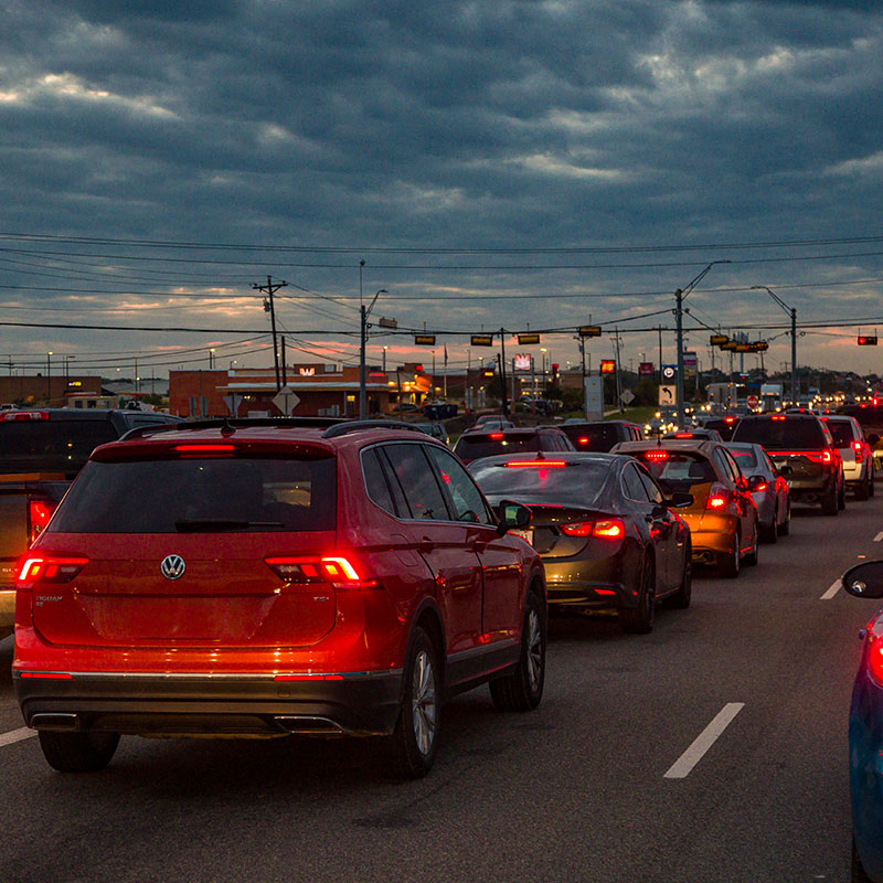 Heavy evening traffic congestion on 290 with vehicles stopped in multiple lanes under a cloudy sky