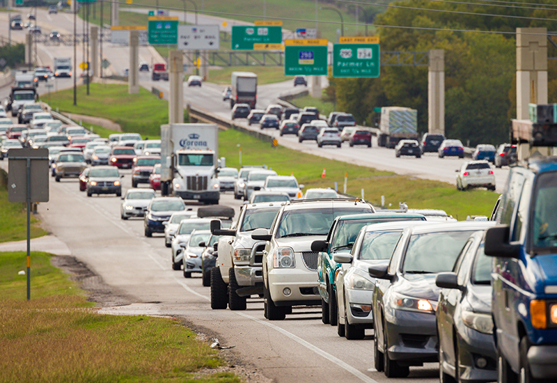 Daytime traffic backup on 290 with cars and trucks in slow-moving lanes