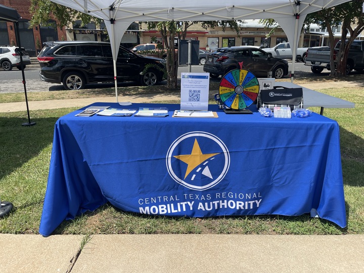 A Central Texas Regional Mobility Authority table set up with fact sheets and giveaways at the La Cultura festival.